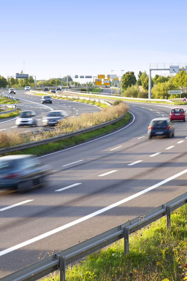154917585 Mehrspurige Straße mit fließendem Verkehr in einer Kurve